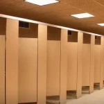 Why do public bathroom doors not reach the floor?